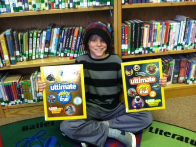 Lachlan poses with two of the books his donation purchased.